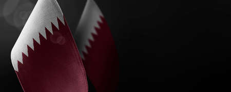 Small national flags of the Qatar on a dark backgroundの写真素材