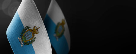 Small national flags of the San Marino on a dark backgroundの写真素材
