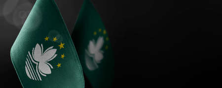 Small national flags of the Macao on a dark background