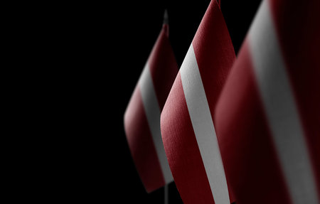Small national flags of the Latvia on a black backgroundの写真素材
