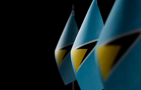 Small national flags of the Saint Lucia on a black background