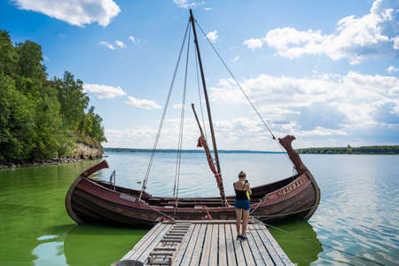 An ancient wooden boat on the pier in the Bogatyrskaya Sloboda in the Samara region in Russia. A clear sunny day on July 28, 2021のeditorial素材