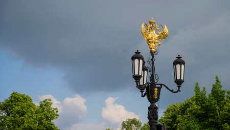 A street lamp with the coat of arms of Russia in Krasnodar, Russia. Cloudy Day May 23, 2021のeditorial素材