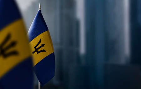 Small flags of Barbados on a blurry background of the city