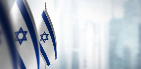 Small flags of Israel on a blurry background of the cityの写真素材