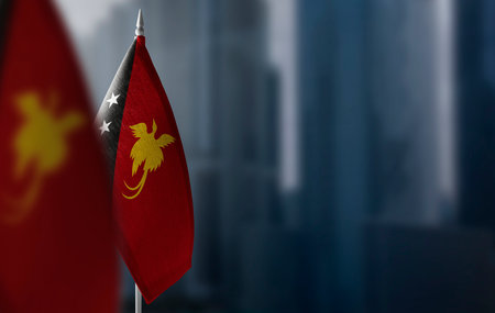 Small flags of Papua New Guinea on a blurry background of the cityの写真素材