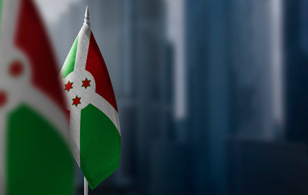 Small flags of Burundi on a blurry background of the city