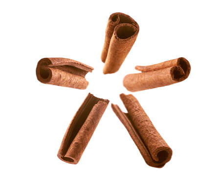 Cinnamon sticks levitate on a white background