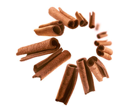 Cinnamon sticks levitate on a white backgroundの写真素材