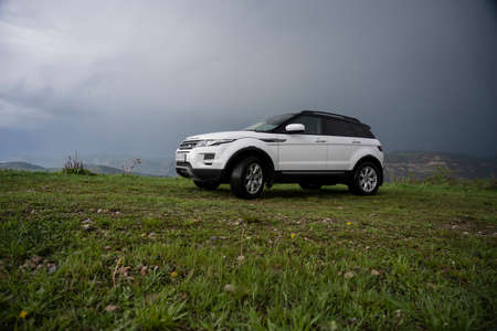 Range Rover Evoque car on the background of the mountains of the North Caucasus in Russia. Cloudy...