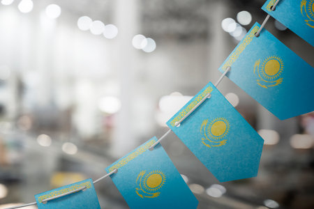 A garland of Kazakhstan national flags on an abstract blurred background