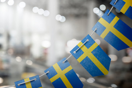 A garland of Sweden national flags on an abstract blurred background.の写真素材