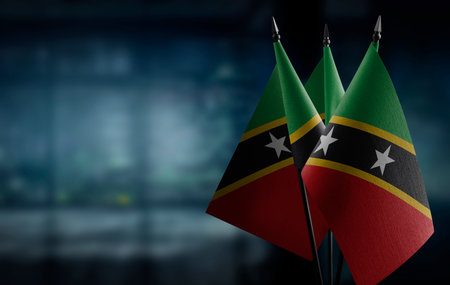 Small flags of the Saint Kitts and Nevis on an abstract blurry background.の写真素材
