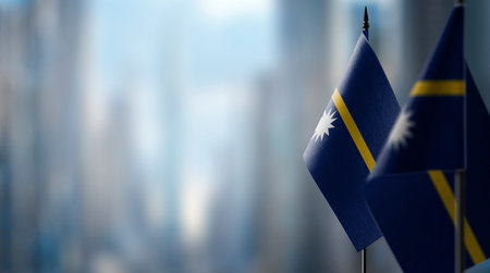 Small flags of the Nauru on an abstract blurry background.