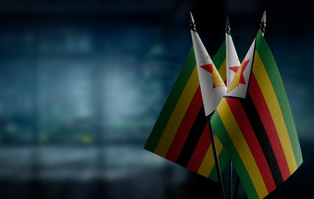 Small flags of the Zimbabwe on an abstract blurry background.の写真素材