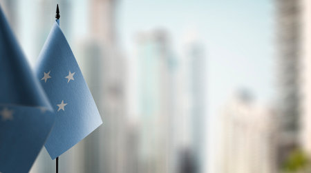Small flags of the Federated States of Micronesia on an abstract blurry background.