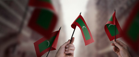 A group of people holding small flags of the Maldives in their hands.の写真素材