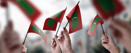 A group of people holding small flags of the Maldives in their hands.の写真素材