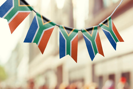 A garland of South Africa national flags on an abstract blurred background.の写真素材