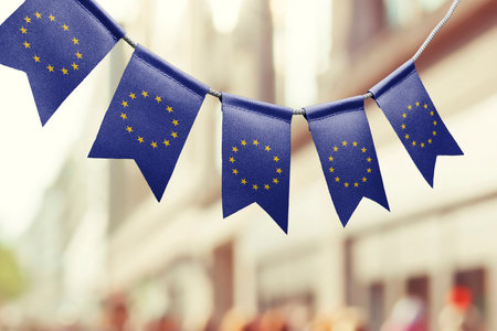 A garland of European Union national flags on an abstract blurred background.の写真素材