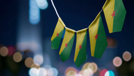A garland of French Guiana national flags on an abstract blurred background.の写真素材