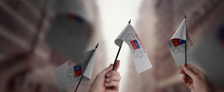 A group of people holding small flags of the Mayotte in their hands.の写真素材