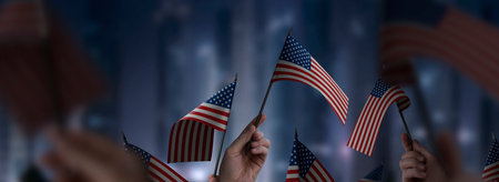 USA flags in their hands on a blurred urban backgroundの写真素材