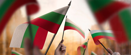 Bulgaria flags in their hands on a blurred urban backgroundの写真素材
