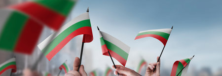 Bulgaria flags in their hands on a blurred urban backgroundの写真素材