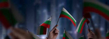 Bulgaria flags in their hands on a blurred urban backgroundの写真素材