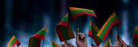 Lithuania flags in their hands on a blurred urban backgroundの写真素材