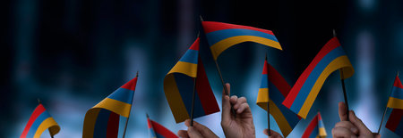 Armenia flags in their hands on a blurred urban backgroundの写真素材