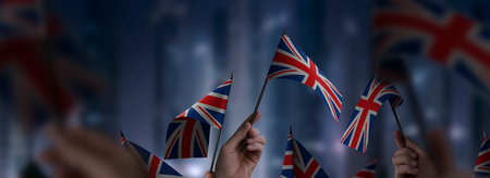 United Kingdom flags in their hands on a blurred urban backgroundの写真素材