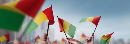 Guinea flags in their hands on a blurred urban backgroundの写真素材