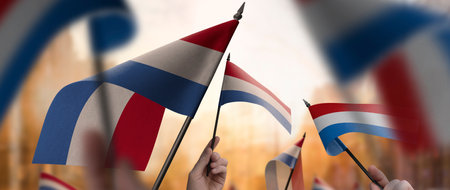 Netherlands flags in their hands on a blurred urban backgroundの写真素材