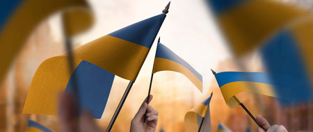 Ukraine flags in their hands on a blurred urban backgroundの写真素材