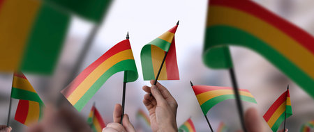 Bolivia flags in their hands on a blurred urban background
