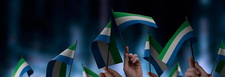 Sierra Leone flags in their hands on a blurred urban background