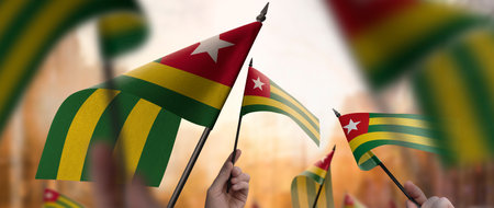 Togo flags in their hands on a blurred urban backgroundの写真素材