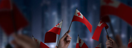 Tonga flags in their hands on a blurred urban background