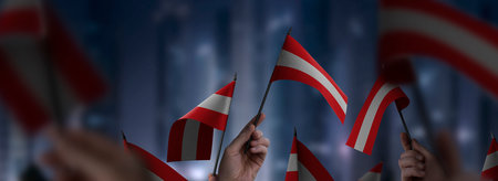 Austria flags in their hands on a blurred urban background. The photo illustration was created...