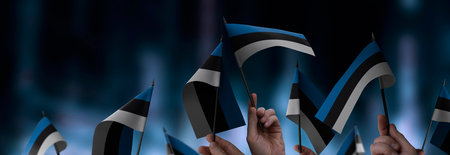 Estonia flags in their hands on a blurred urban background