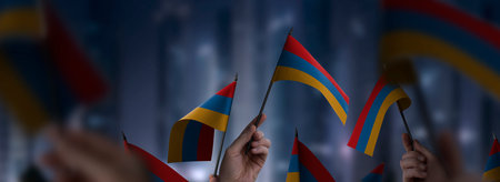 Armenia flags in their hands on a blurred urban backgroundの写真素材