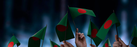 Bangladesh flags in their hands on a blurred urban backgroundの写真素材