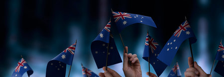 Australia flags in their hands on a blurred urban backgroundの写真素材