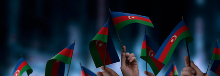 Azerbaijan flags in their hands on a blurred urban backgroundの写真素材