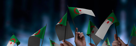 Algeria flags in their hands on a blurred urban background