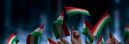 Hungary flags in their hands on a blurred urban backgroundの写真素材