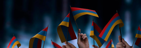 Armenia flags in their hands on a blurred urban backgroundの写真素材