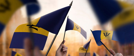 Barbados flags in their hands on a blurred urban backgroundの写真素材